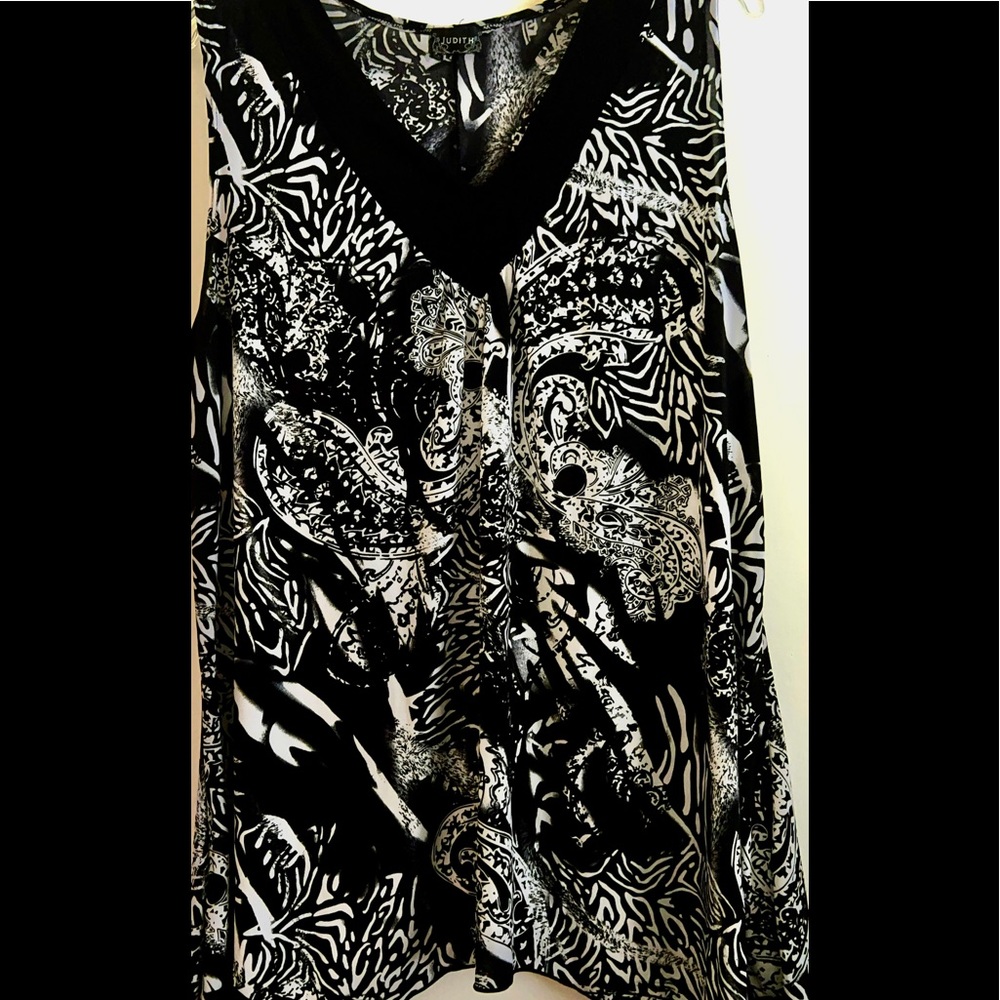 Sleeveless, very cute & soft top. Design is slimming. Almost brand new.